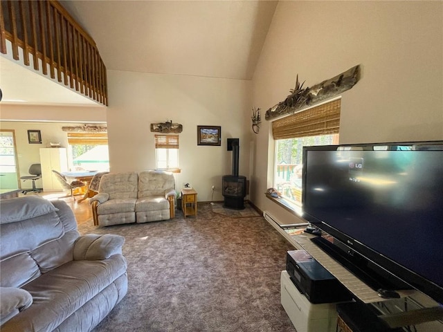 carpeted living room with a wood stove and high vaulted ceiling