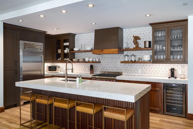 kitchen featuring premium range hood, sink, beverage cooler, stainless steel built in fridge, and range