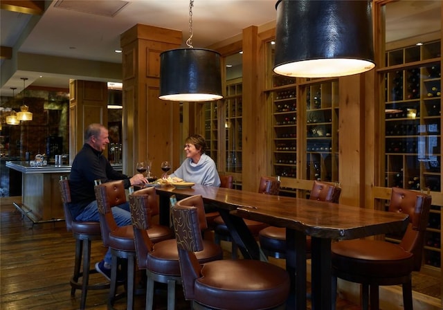 bar featuring dark hardwood / wood-style flooring and decorative light fixtures