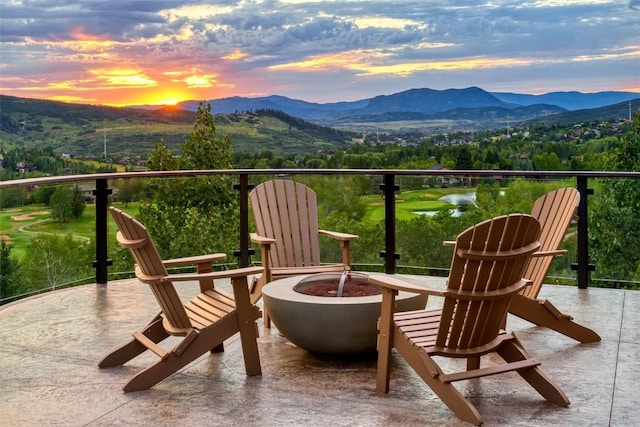 balcony at dusk featuring a fire pit and a mountain view