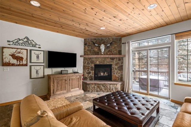 living room featuring a stone fireplace and wood ceiling