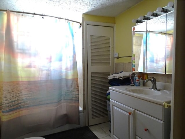 bathroom with tile patterned flooring, vanity, shower / bath combination with curtain, and a textured ceiling