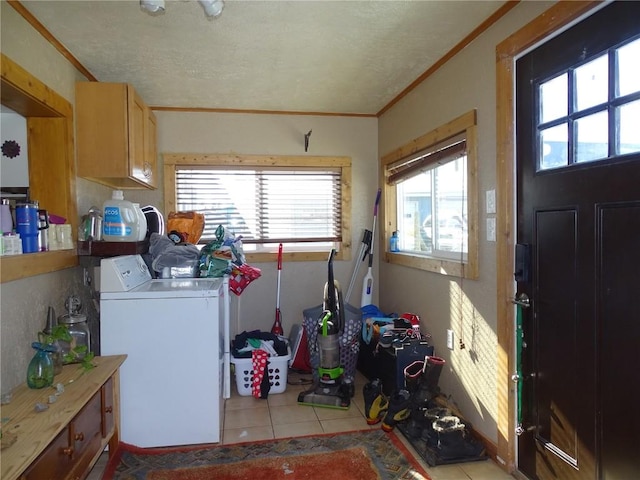 washroom featuring light tile patterned flooring, cabinets, a healthy amount of sunlight, and separate washer and dryer