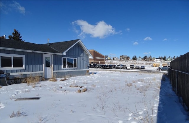 view of snow covered back of property