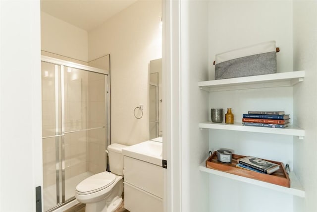 bathroom featuring vanity, an enclosed shower, and toilet