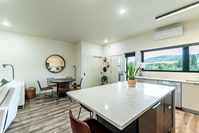 kitchen with a wealth of natural light, dishwasher, a center island, and a wall mounted air conditioner