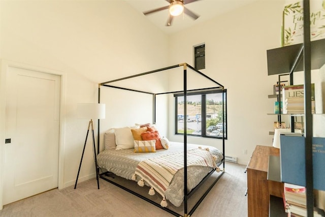 carpeted bedroom featuring ceiling fan and a high ceiling