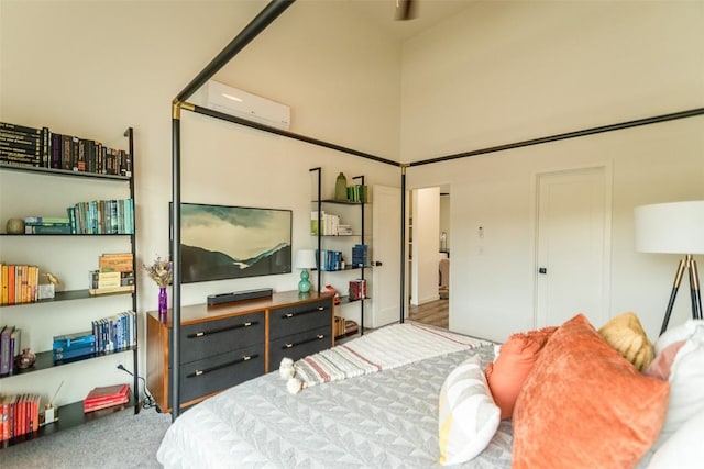 bedroom with an AC wall unit and a high ceiling