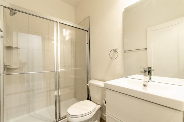 bathroom with vanity, toilet, and walk in shower