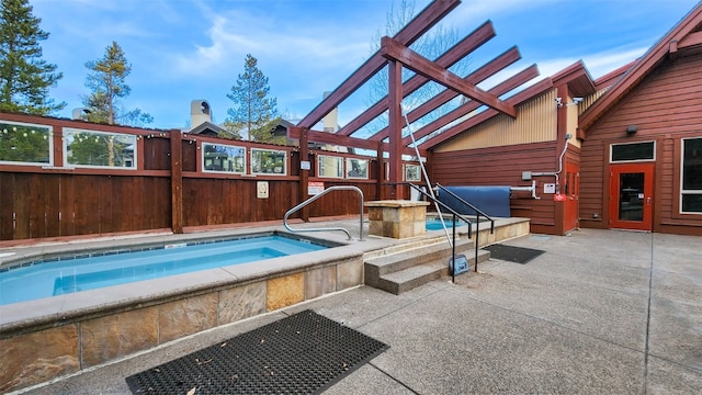 view of swimming pool with a patio area and an indoor hot tub