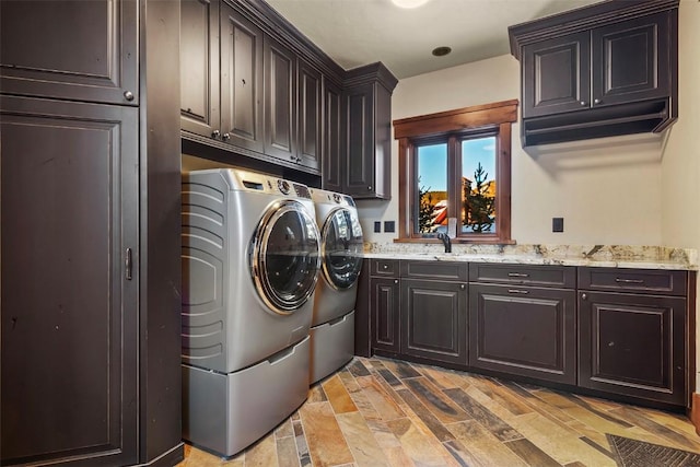 laundry room with cabinets, washing machine and dryer, and sink