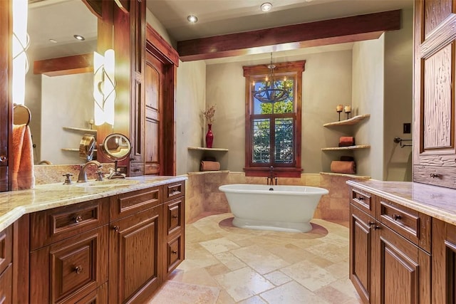 bathroom with a tub, vanity, and a notable chandelier