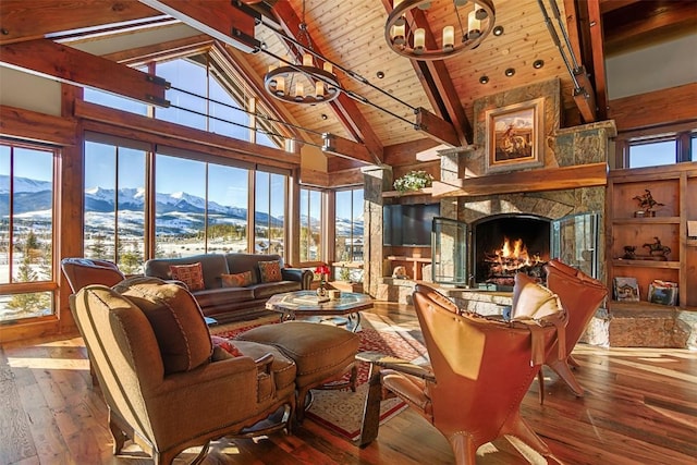 living room featuring beam ceiling, high vaulted ceiling, wooden ceiling, hardwood / wood-style floors, and a stone fireplace