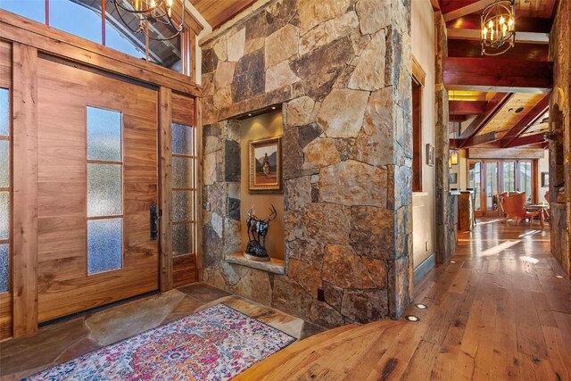 foyer featuring hardwood / wood-style floors, wooden ceiling, high vaulted ceiling, a notable chandelier, and beam ceiling