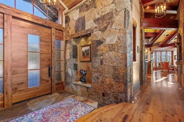 foyer featuring hardwood / wood-style floors, wooden ceiling, high vaulted ceiling, a notable chandelier, and beam ceiling