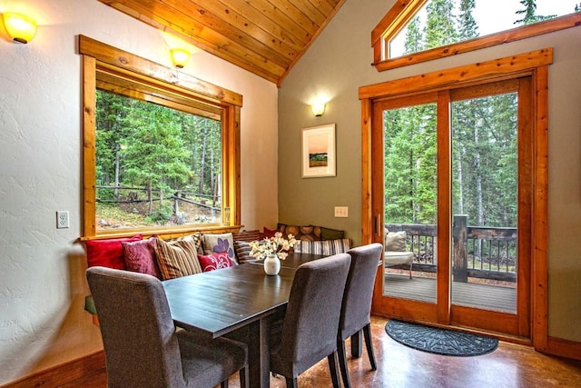 dining space featuring concrete flooring, wood ceiling, and vaulted ceiling