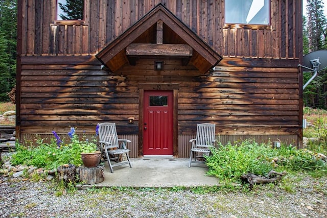 view of exterior entry with a patio area