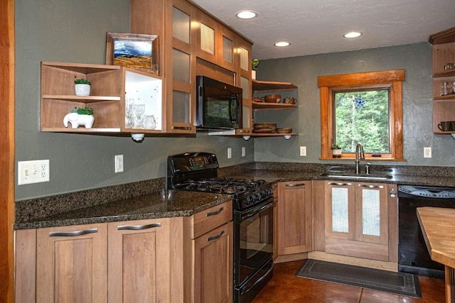 kitchen featuring sink, dark stone counters, and black appliances