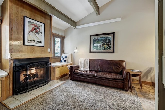 living area featuring lofted ceiling with beams, a lit fireplace, and baseboards