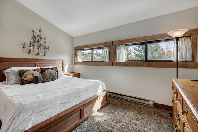 carpeted bedroom with a baseboard heating unit and lofted ceiling