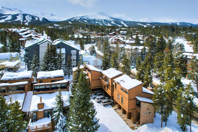 snowy aerial view with a residential view and a mountain view