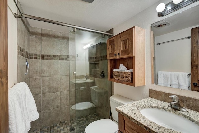 full bathroom with toilet, a stall shower, and vanity