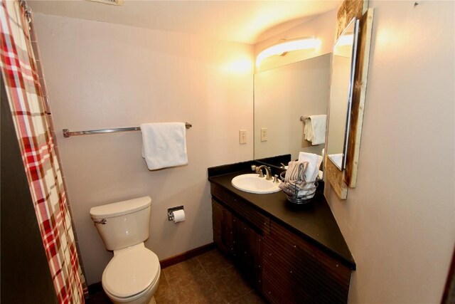 full bath featuring a shower with shower curtain, vanity, toilet, and baseboards