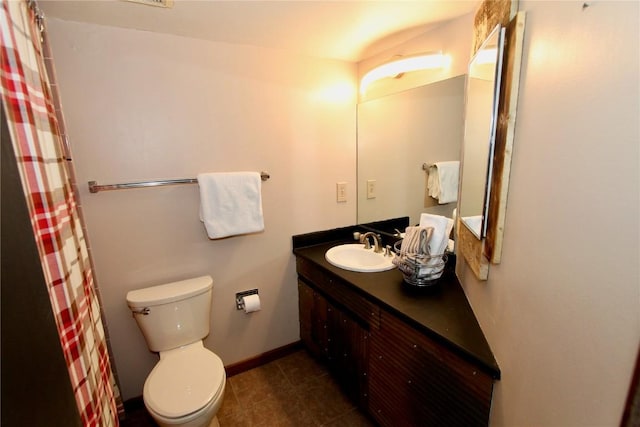 bathroom with toilet, curtained shower, baseboards, and vanity