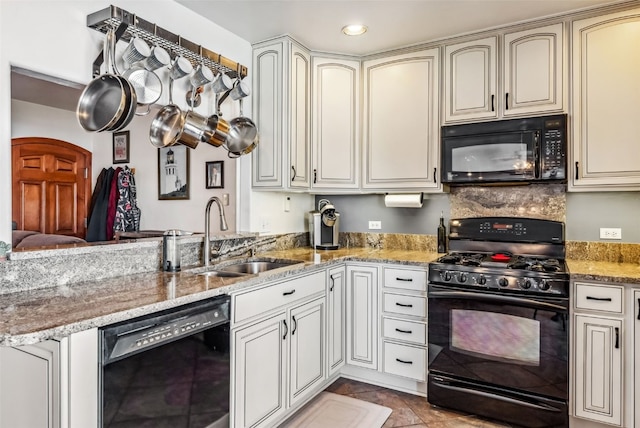 kitchen featuring sink, light stone counters, cream cabinets, light tile patterned floors, and black appliances