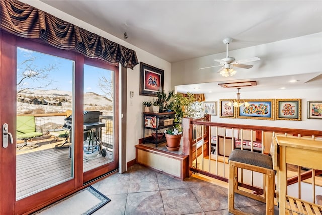 doorway with tile patterned flooring, a mountain view, and ceiling fan