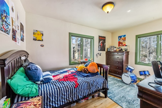 bedroom with wood-type flooring and multiple windows