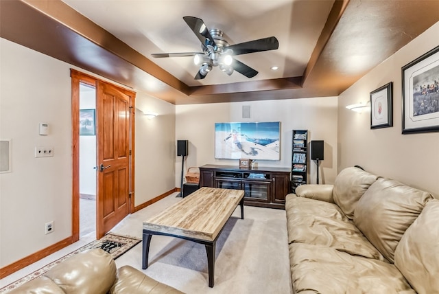 living room featuring ceiling fan, a raised ceiling, and light carpet