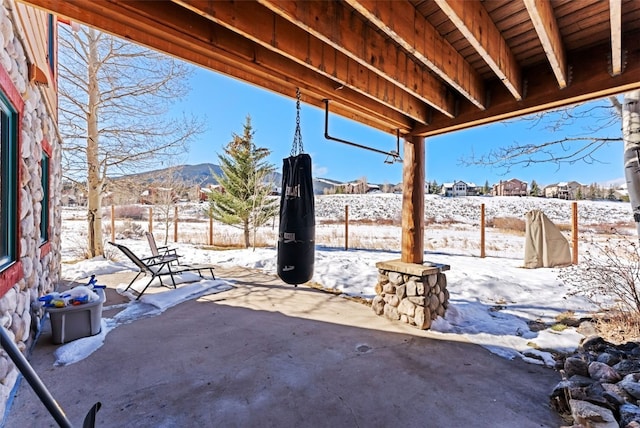 snow covered patio with a mountain view