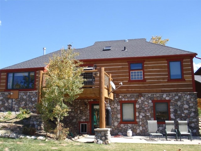 rear view of property featuring a patio area and a balcony