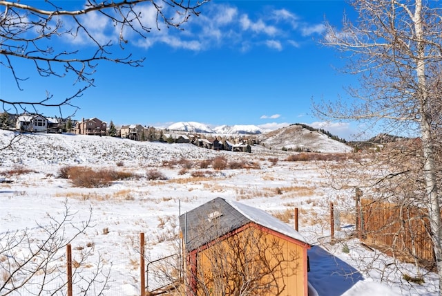 yard covered in snow featuring a mountain view