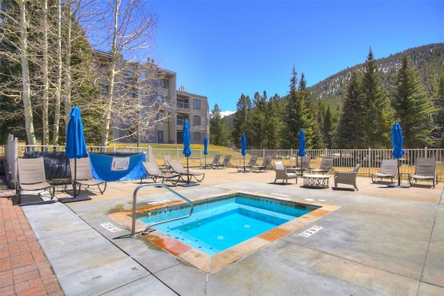 view of swimming pool featuring a hot tub and a patio