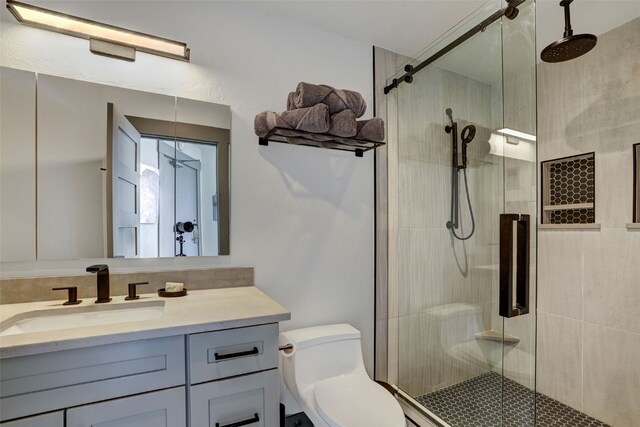 bathroom with vanity, toilet, and a shower with shower door