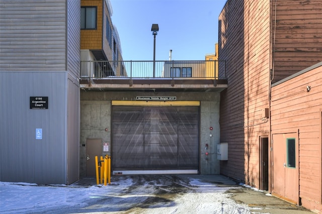 snow covered property with a garage