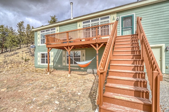 rear view of house featuring stairway and a wooden deck