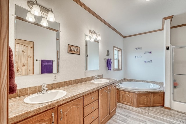 full bathroom with wood finished floors, a stall shower, a sink, and crown molding