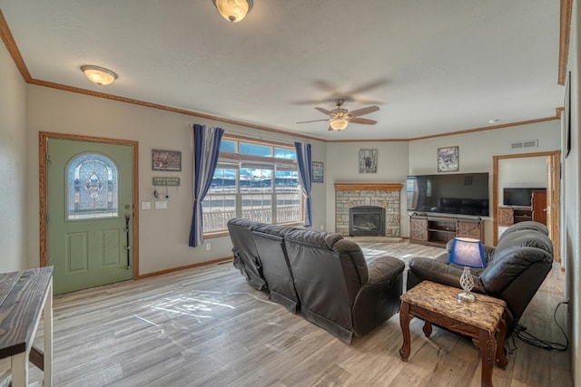 living area with crown molding, a fireplace, visible vents, light wood-type flooring, and baseboards