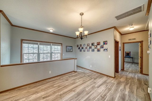 unfurnished room featuring light wood-style floors, baseboards, and visible vents