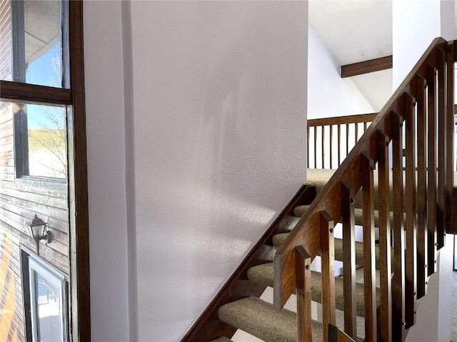 staircase with vaulted ceiling with beams