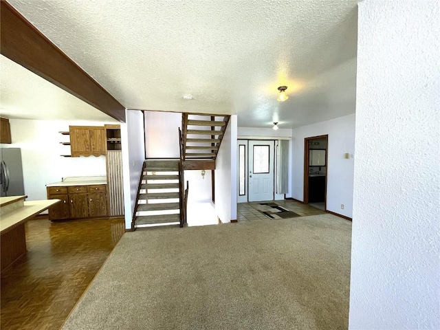 unfurnished living room with a textured ceiling and dark carpet