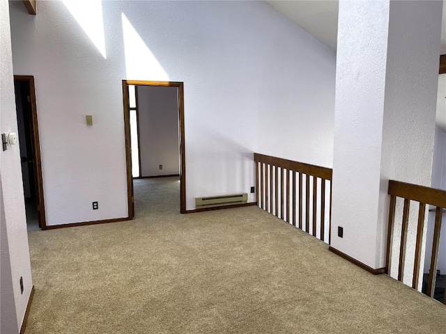 empty room featuring carpet floors and a baseboard heating unit