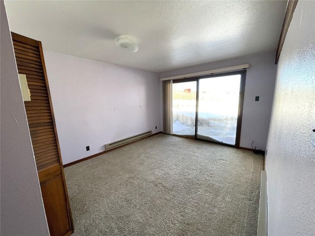 unfurnished room featuring carpet flooring, a textured ceiling, and a baseboard radiator