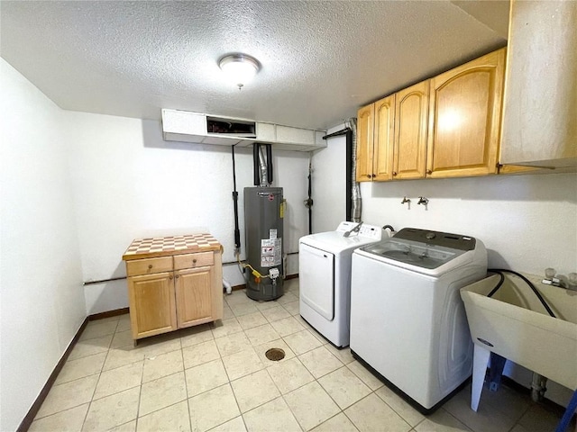 laundry area with cabinets, a textured ceiling, water heater, washing machine and dryer, and light tile patterned flooring