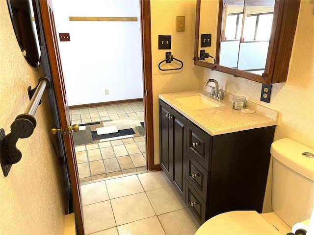 bathroom with tile patterned flooring, vanity, and toilet