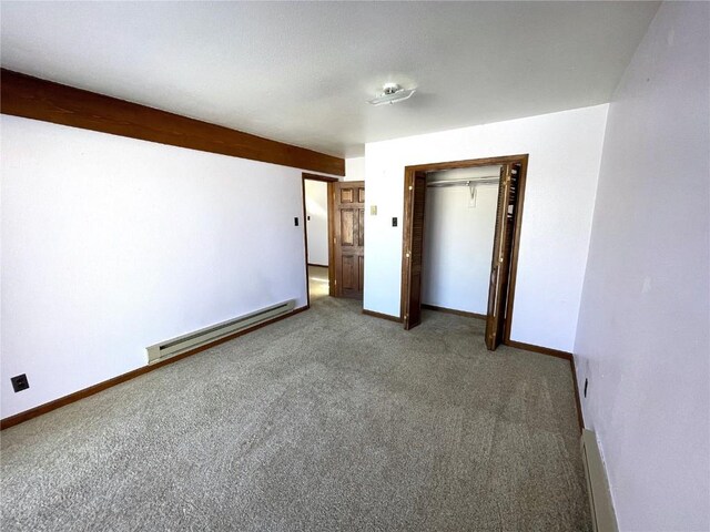 unfurnished bedroom featuring carpet floors, baseboard heating, and a closet