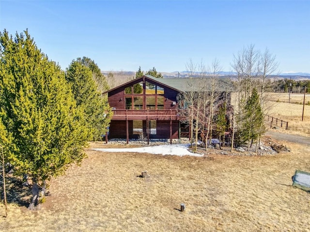 rear view of property featuring a wooden deck and stairs